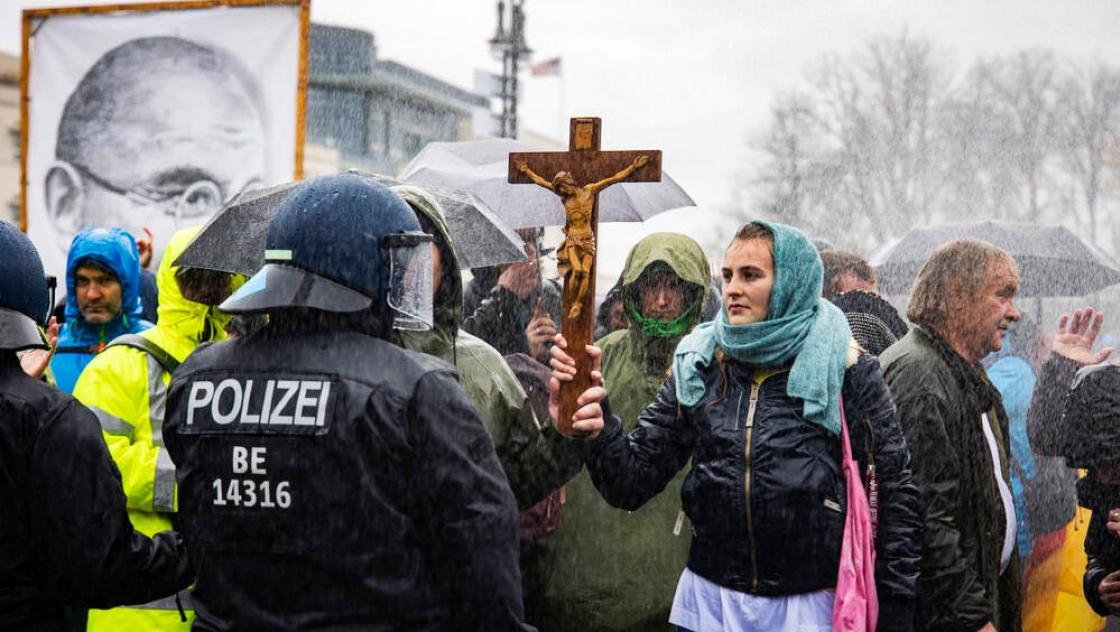 Eine Frau haelt einen Kreuz waehren einer Demonstration gegen den Veraenderungen vom Infektionsschutzgesetz in Berlin am 18. November 2020.