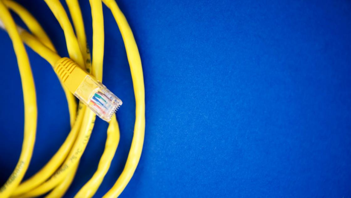 Gelbes Netzwerkkabel auf blauem Grund