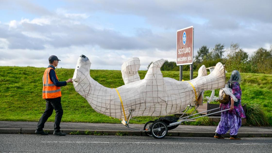 Bamber Hawes (links) und seine Skulptur Clarion, der Eisbär, überqueren die Grenze nach Schottland bei Gretna. Sie sind auf dem Weg zur COP26, um auf die Klimakrise aufmerksam zu machen, 24.10.2021 (IMAGO / i Images)