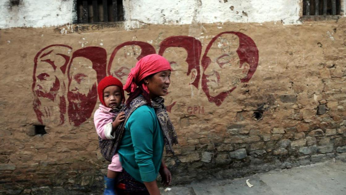 Eine Frau, die ihr Baby auf dem Rücken trägt, vor einer Wandmalerei im Dorf Thabang in Rolpa, dem westlichen Bezirk Nepals, 11.10.2020 (IMAGO / ZUMA Wire) Eine Frau, die ihr Baby auf dem Rücken trägt, vor einer Wandmalerei im Dorf Thabang in Rolpa, dem westlichen Bezirk Nepals, 11.10.2020 (IMAGO / ZUMA Wire)