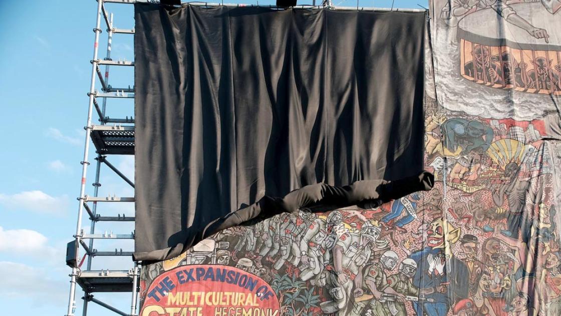 Ein Banner des indonesischen Künstlerkollektivs Taring Padi mit eindeutig antisemitischen Darstellungen wird auf der documenta fifteen in Kassel verhüllt, 20.6.2022 (IMAGO / Hartenfelser)