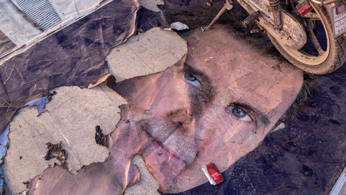 Ein zerstörtes Bild von Baschar al-Assad in Aleppo, 2.12.2024 (IMAGO / ABACAPRESS / Ugur Yildirim)