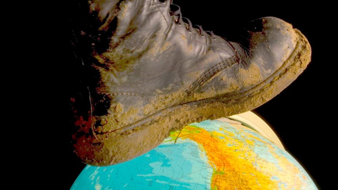 Symbolbild: Ein Stiefel tritt auf einen Erdball (IMAGO / blickwinkel)
