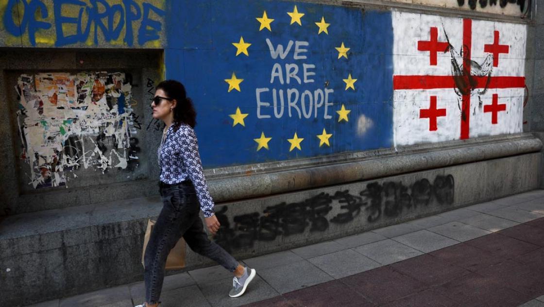 Eine Frau geht an einem pro-europäischen Graf­fi­to in Tbilissi entlang, 25.9.2025 (IMAGO / NurPhoto)