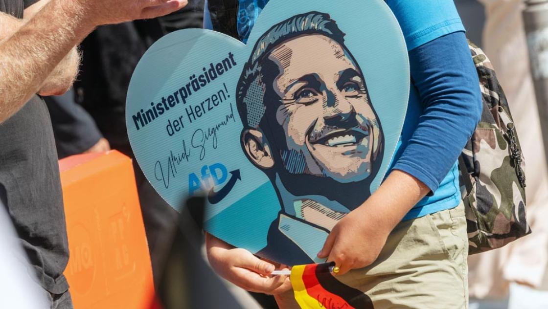 AfD-Fanartikel in Herzform an einem Wahlkampfstand in Magdeburg, 28.7.2026 (IMAGO / Wolfgang Maria Weber)