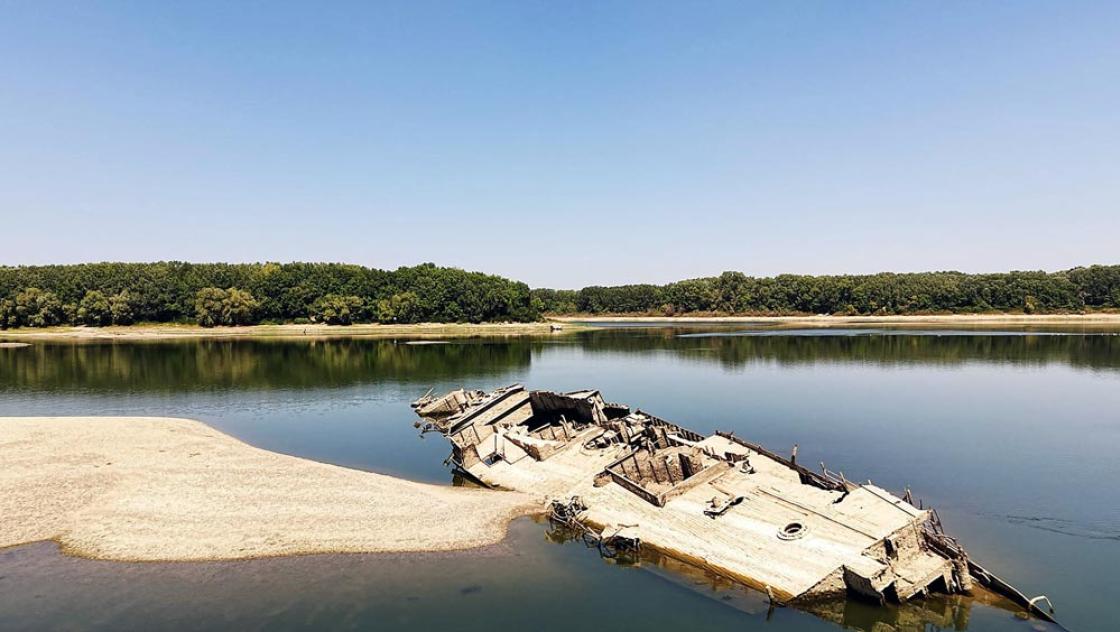 »Wie die Kriegsschiffe, die bei Niedrigwasser zum Vorschein kommen, scheint auch der Faschismus ein Comeback zu erleben«, schreiben unsere Autorinnen. Zu sehen ist ein Kriegsschiff, was durch niedrige Pegelstände in Serbien aus der Donau aufgetaucht ist, 11.8.2026 (IMAGO / Anadolu Agency)