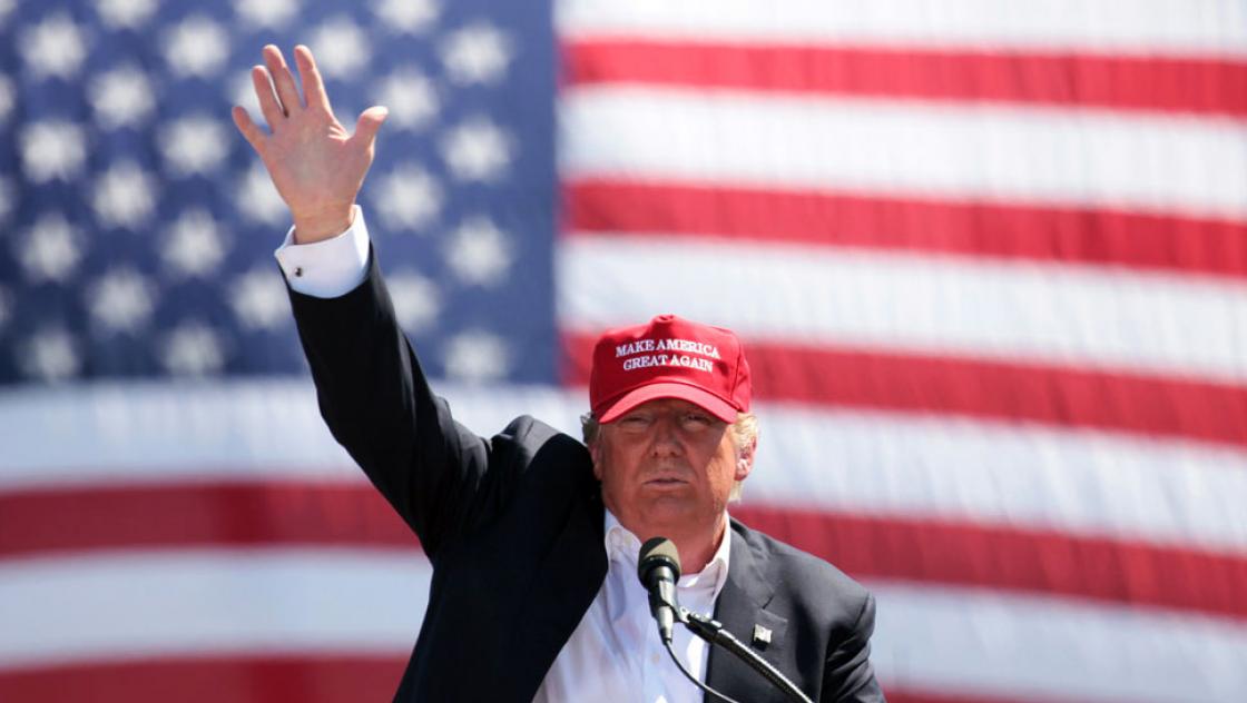 Donald Trump hebt den rechten Arm bei einem Wahlkampfauftritt