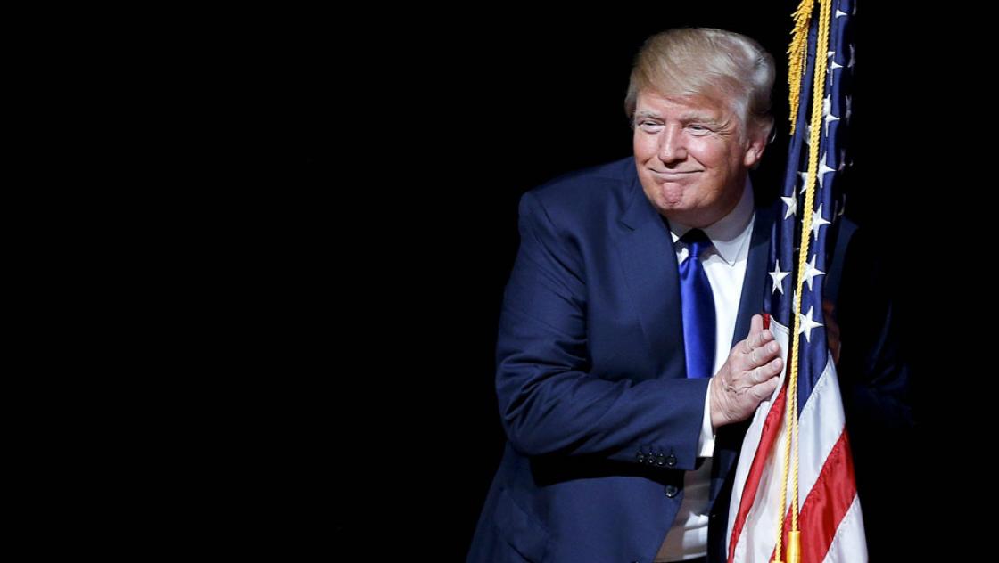 Donald Trump umarmt die amerikanische Flagge