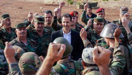 Syriens Präsident Assad inmitten Fäuste reckender Soldaten