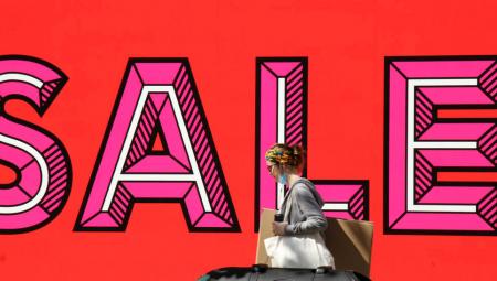 12. Juli 2020, London: Eine Käuferin geht inmitten der Coronakrise an einem SALE-Schild vorbei.
