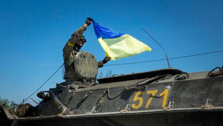Ein ukrainischer Soldat schwenkt eine ukrainische Flagge aus einem russischen Kettenfahrzeug, 13.5.2022 (IMAGO / ZUMA Wire)