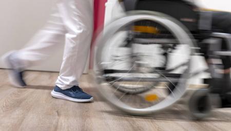 EinePflegekraft schiebt einen Rollstuhl im Pflegeheim in Heidelberg, 30.3.2022 (IMAGO / photothek / Ute Grabowsky)
