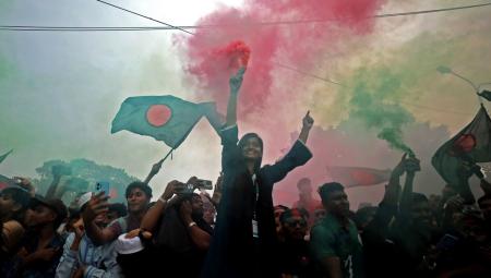 Menschen feiern den ersten Jahrestag der von Studierenden angeführten Proteste, die zum Sturz der ehemaligen Premierministerin von Bangladesch, Sheikh Hasina, geführt haben vor dem Parlamentsgebäude in Dhaka, 5.8.2025 (IMAGO / NurPhoto / Maruf Rahman)