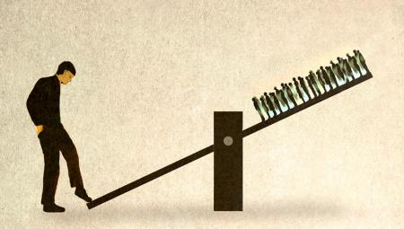 Wippe mit einer großen Person links und vielen kleinen Menschen rechts oben. (IMAGO / Westend61)