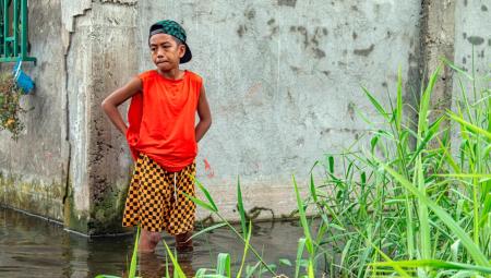 Ein Kind steht knietief im Hochwasser. Der Stadtteil steht seit Wochen unter Wasser. Einwohner der Philippinen haben ein besonders hohes Risiko, Opfer von Naturkatastrophen zu werden, 16.9.2025 (IMAGO / ZUMA Press Wire)