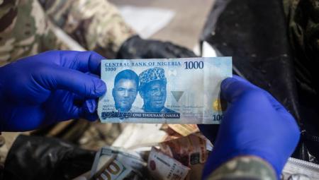 Ein Freiwilliger der Organisation »Platsdarm« zeigt eine nigerianische Banknote, die ein toter afrikanischer Soldat bei sich trug, der an der Front in der Region Donezk in der Ukraine für Russland gekämpft hatte, 28.6.2026 (IMAGO / Anadolu Agency / Francisco Richart)