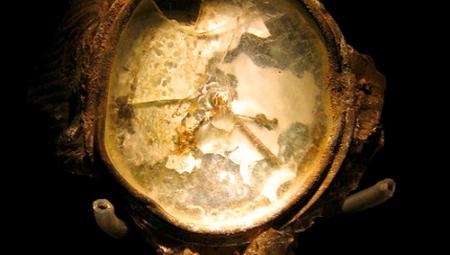 Das Bild zeigt eine verrostete und geschmolzene Armbanduhr