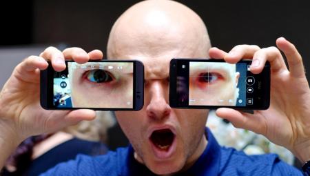 Ein Mann hält zwei Smartphones vor sein Gesicht
