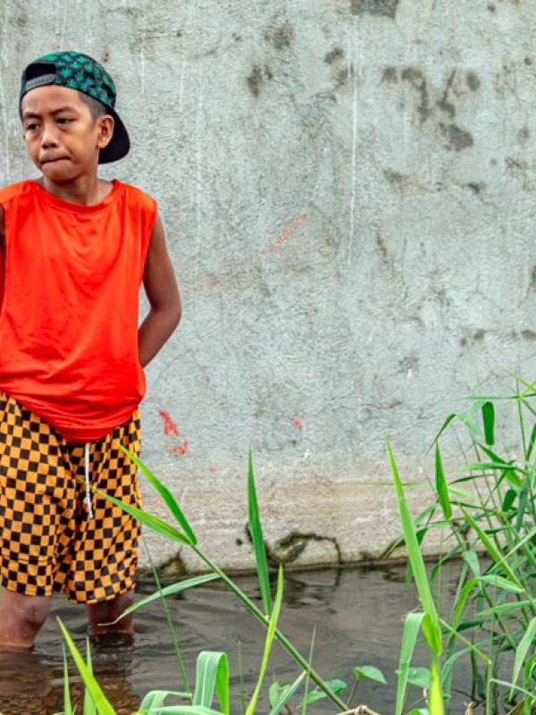 Ein Kind steht knietief im Hochwasser. Der Stadtteil steht seit Wochen unter Wasser. Einwohner der Philippinen haben ein besonders hohes Risiko, Opfer von Naturkatastrophen zu werden, 16.9.2025 (IMAGO / ZUMA Press Wire)