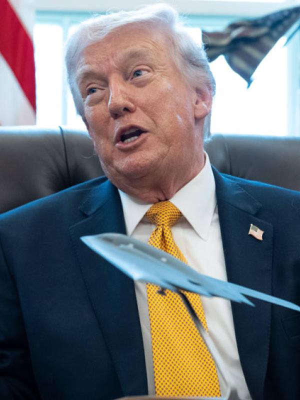 US-Präsident Donald Trump im Oval Office mit einem Modell eines B-2-Spirit-Bombers auf seinem Schreibtisch, 16.3.2026 (IMAGO / MediaPunch) 