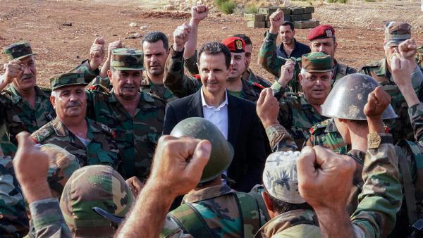 Syriens Präsident Assad inmitten Fäuste reckender Soldaten