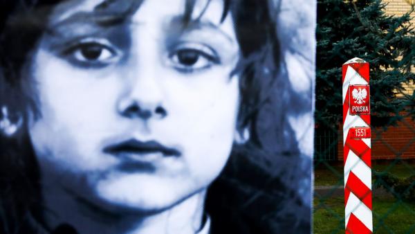 Ein Banner mit dem Bild eines Flüchtlingskindes neben einem polnischen Grenzmarkierungspfahl bei Michalowo (Polen), 23.10.2021 (IMAGO / NurPhoto)