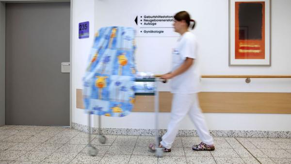 Eine Kinderkrankenschwester schiebt ein neugeborenes Baby im Wagen durch den Flur, Essen, 27.4.2009 (IMAGO / Rupert Oberhäuser)