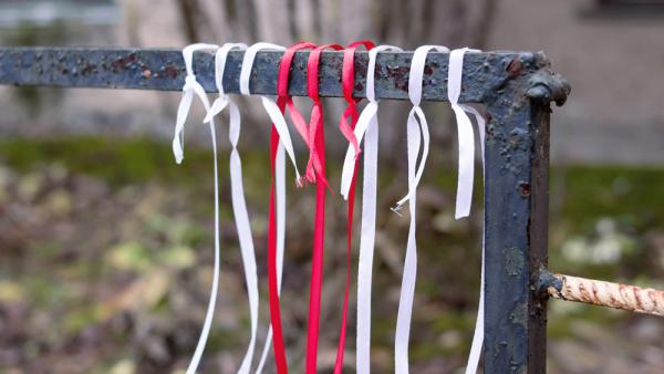 Weiß-rote Bänder an einem Zaun als Zeichen des Protests in Belarus (IMAGO / Pond5)