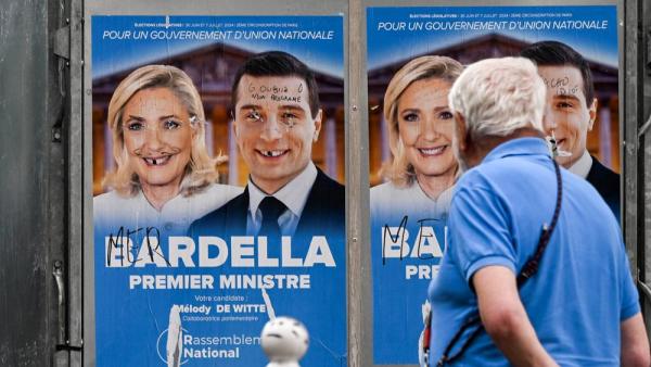 Ein Mann steht vor bemalten Wahlplakaten des Rassemblement National, Paris, 30.6.2024 (IMAGO / NurPhoto / Artur Widak)