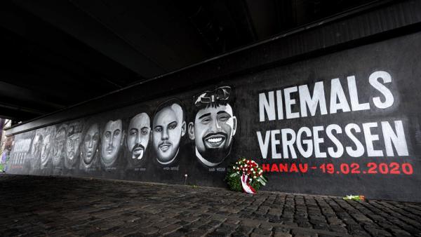 Gedenk-Graffito mit den Gesichtern der Opfer des Hanauer Anschlags und den Worten »Niemals Vergessen« an der Friedensbrücke in Frankfurt (IMAGO / greatif)  