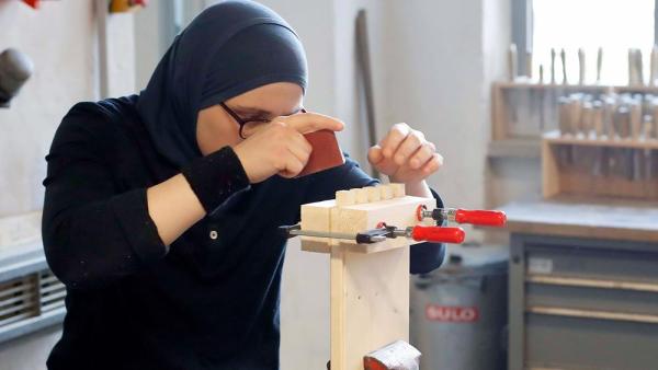 Eine Frau arbeitet in der Übungswerkstatt für Handwerksausbildung der Initiative ARRIVO für Geflüchtete, 30.10.2017 (IMAGO / Berlinfoto)