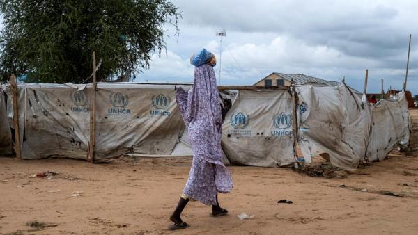 Eine Frau vor dem Registrierungszentrum des UNHCR-Flüchtlingscamps in Adre, Tschad, 1.9.2024 (IMAGO / Martin Bertrand)