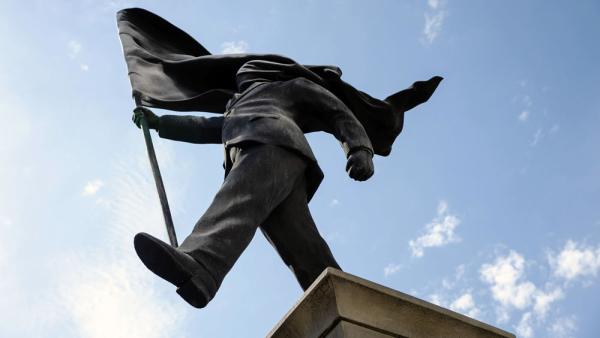 Die Banksy-Skulptur zeigt einen Mann auf einer hohen Säule, in der rechten Hand eine riesige schwarze Flagge, 2.5.2026 (IMAGO / Avalon.red / Pete Speller)