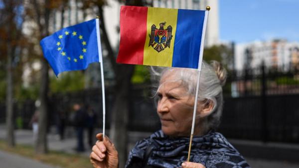 Eine pro-europäische Demonstrantin hält eine Moldau-Flagge in der einen und eine EU-Flagge in der anderen Hand, Chisinau, 29.9.2025 (IMAGO / NurPhoto)