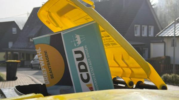 Aus einer Mülltonne schaut ein CDU-Wahlplakat heraus, 14.4.2026 (IMAGO / Rene Traut)